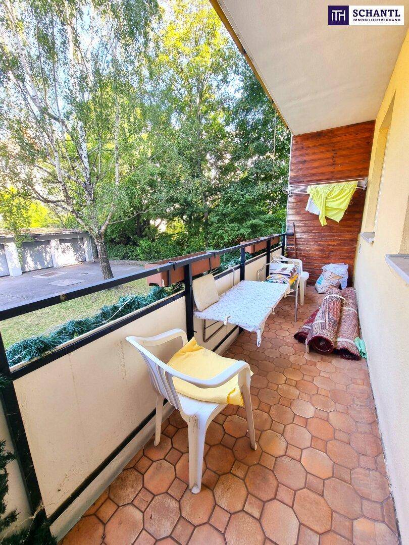 Balkon mit Fliesenboden, Holzverkleidung und einem angenehmen Blick ins Grüne.