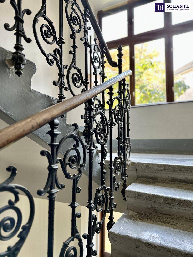 Elegantes Treppenhaus mit schmiedeeisernem Geländer und Marmorstufen.