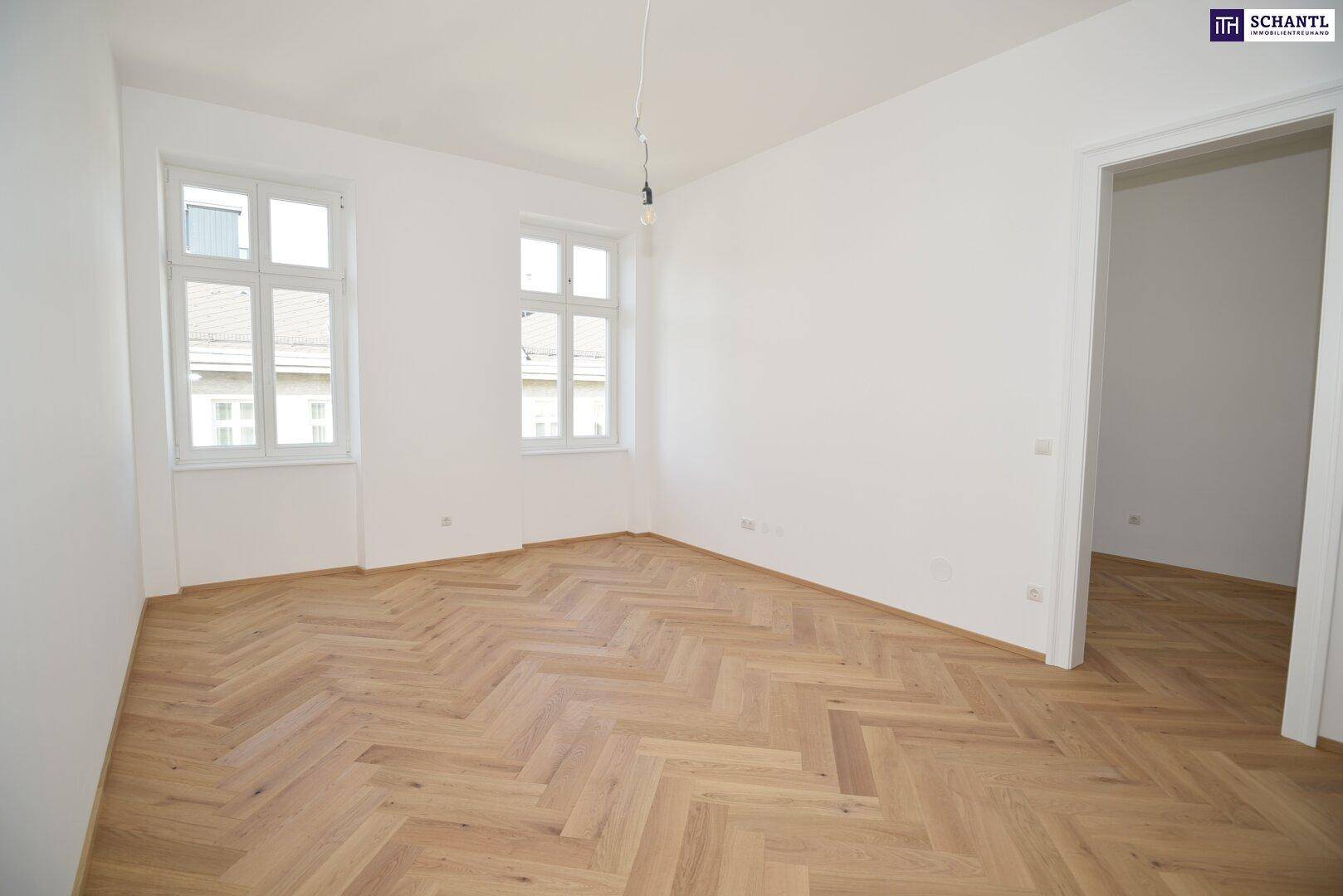Großes, helles Zimmer mit Fischgrätparkett und zwei Fenstern, ideal für Wohnzwecke.