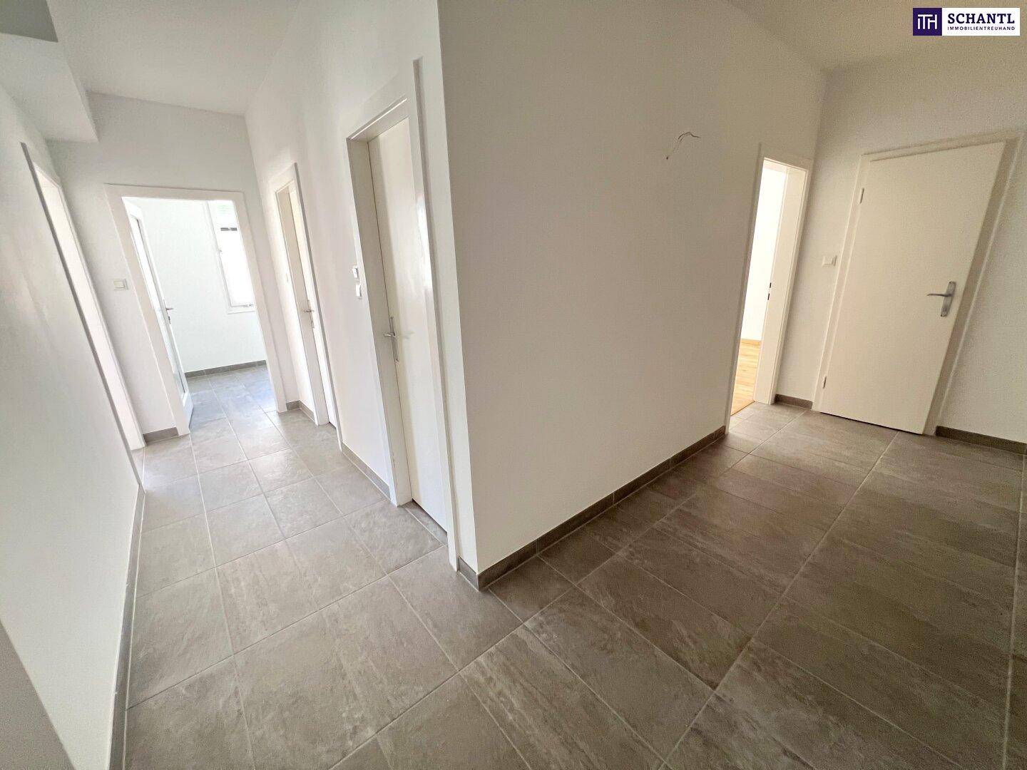 Geräumiger Flur mit Fliesenboden und Zugang zu mehreren Zimmern.