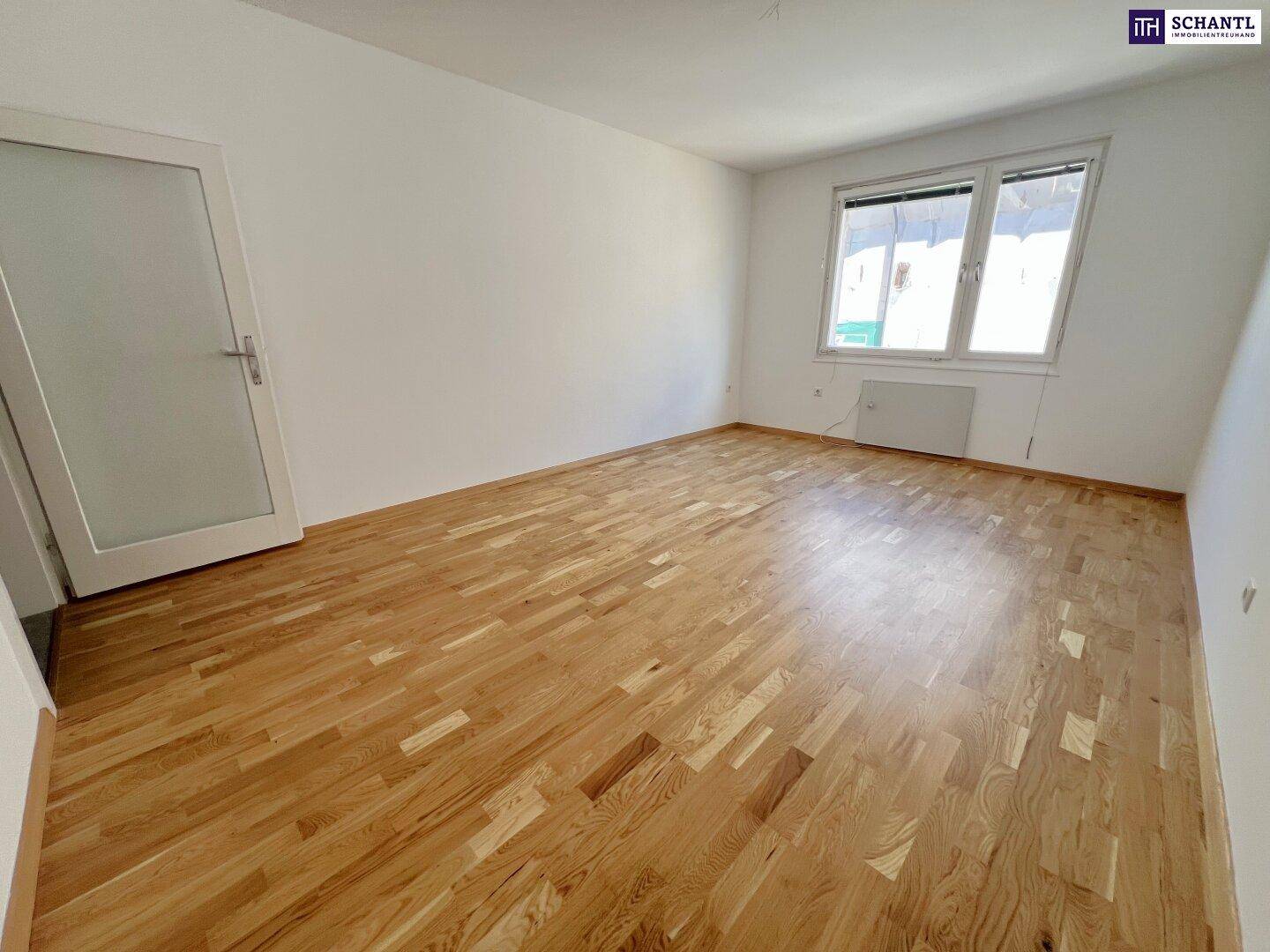 Freundliches Zimmer mit Holzparkett und Fenster, bietet vielseitige Nutzungsmöglichkeiten.