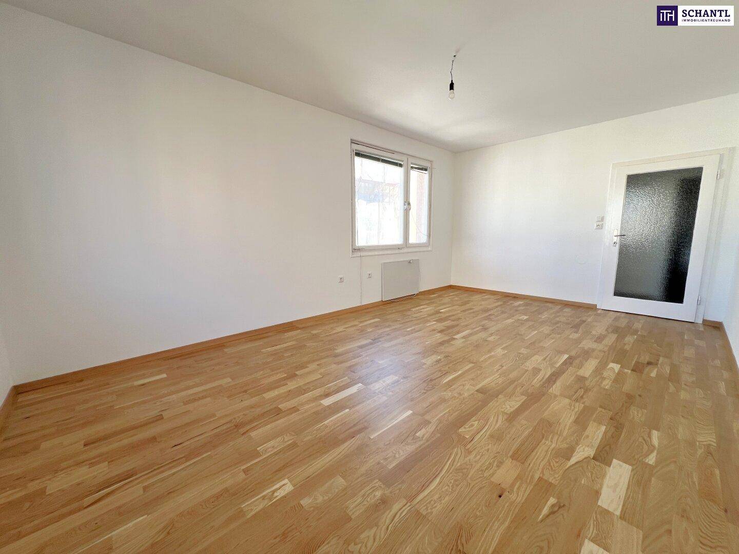 Heller Raum mit Parkettboden und einer Tür mit Glaseinsatz, ideal für Wohnzwecke.