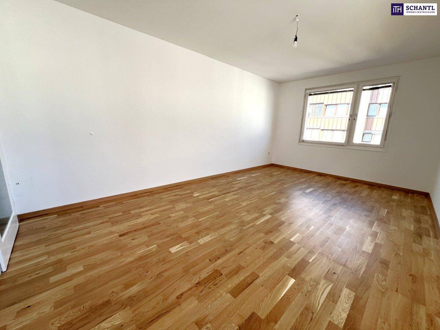 Heller Raum mit Parkettboden und Fenster, bereit für die Einrichtung nach Wunsch.
