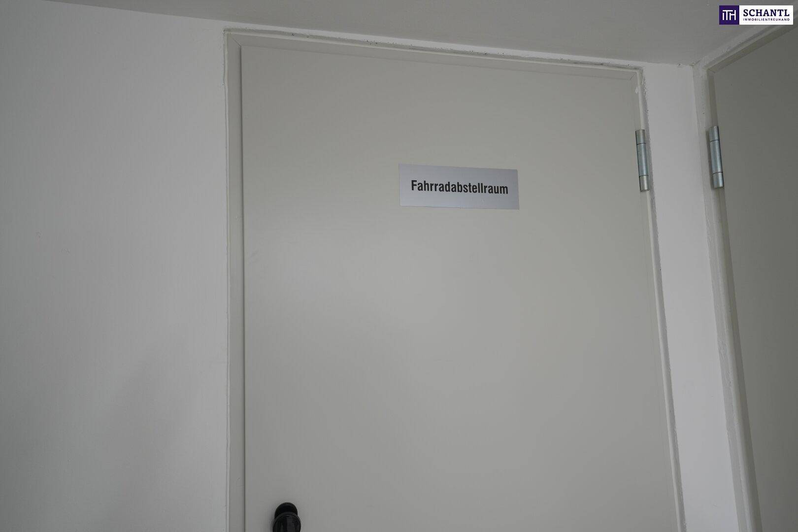 Tür zu einem Fahrradabstellraum im Gebäude, gekennzeichnet mit einem Schild.