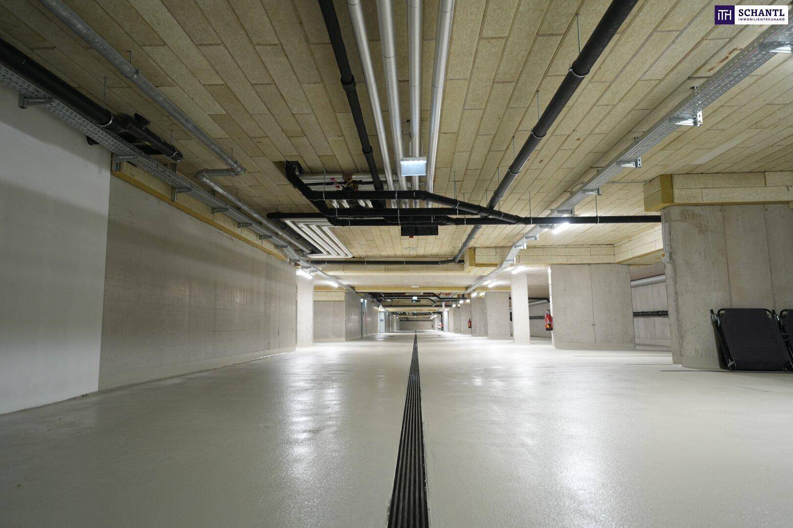 Geräumige Tiefgarage mit Betonwänden und -decken, gut beleuchtet und sauber.