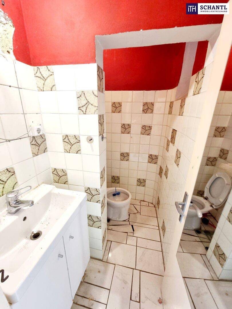 Badezimmer mit Waschbecken, Toilette, Bidet und Duschbereich, renovierungsbedürftig.