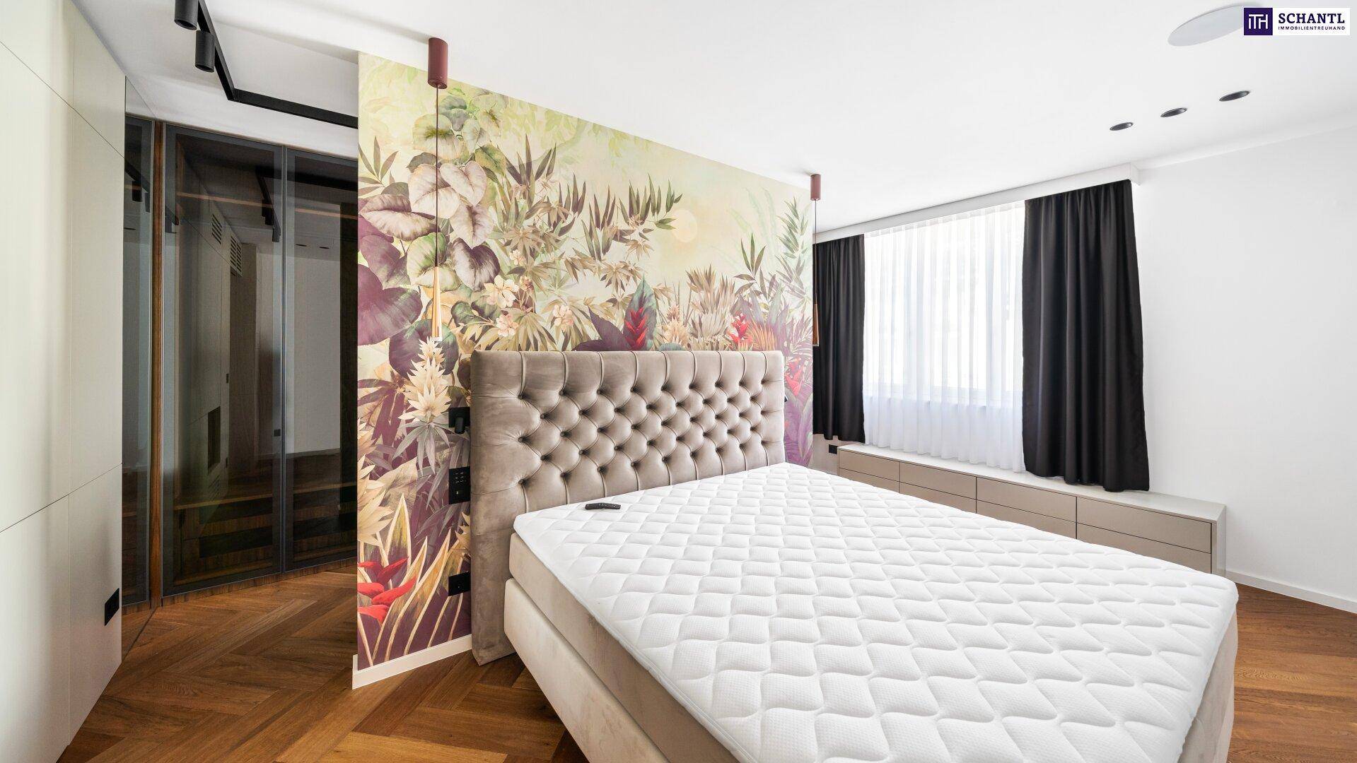 Helles Schlafzimmer mit großem Bett, auffälliger floraler Tapete und Zugang zum begehbaren Kleiderschrank.