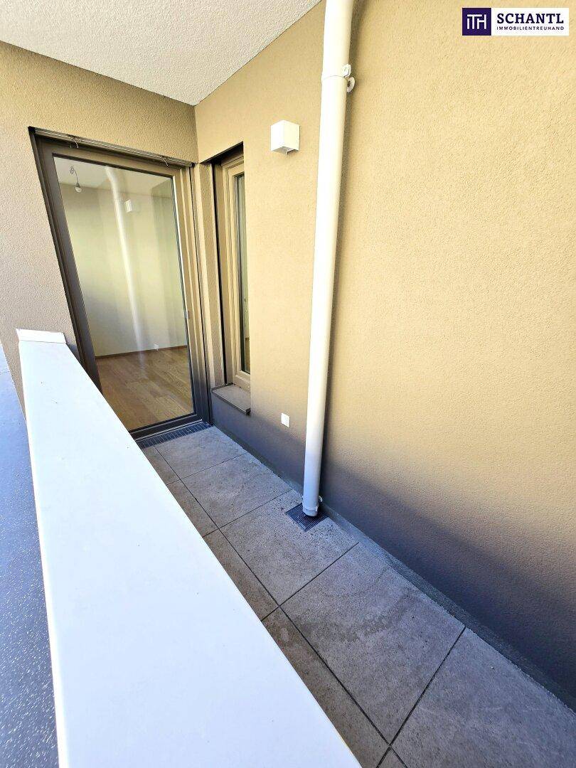 Balkon mit Fliesenboden und weißem Geländer, bietet einen kleinen Außenbereich.