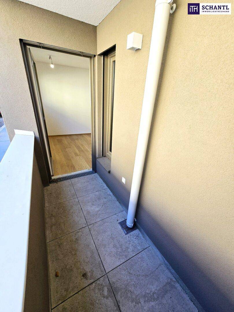 Schmaler Balkon mit Fliesenboden und Zugang zum Innenraum, bietet Platz im Freien.