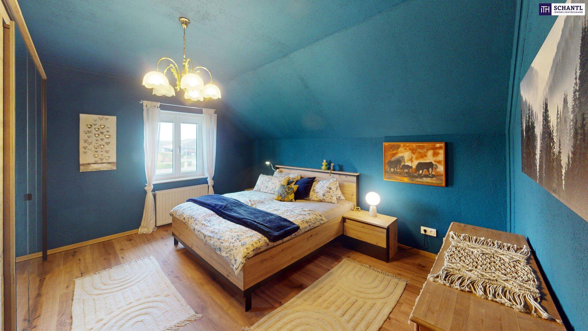 Gemütliches Schlafzimmer mit blauen Wänden, Holzboden und einem großen Bett.