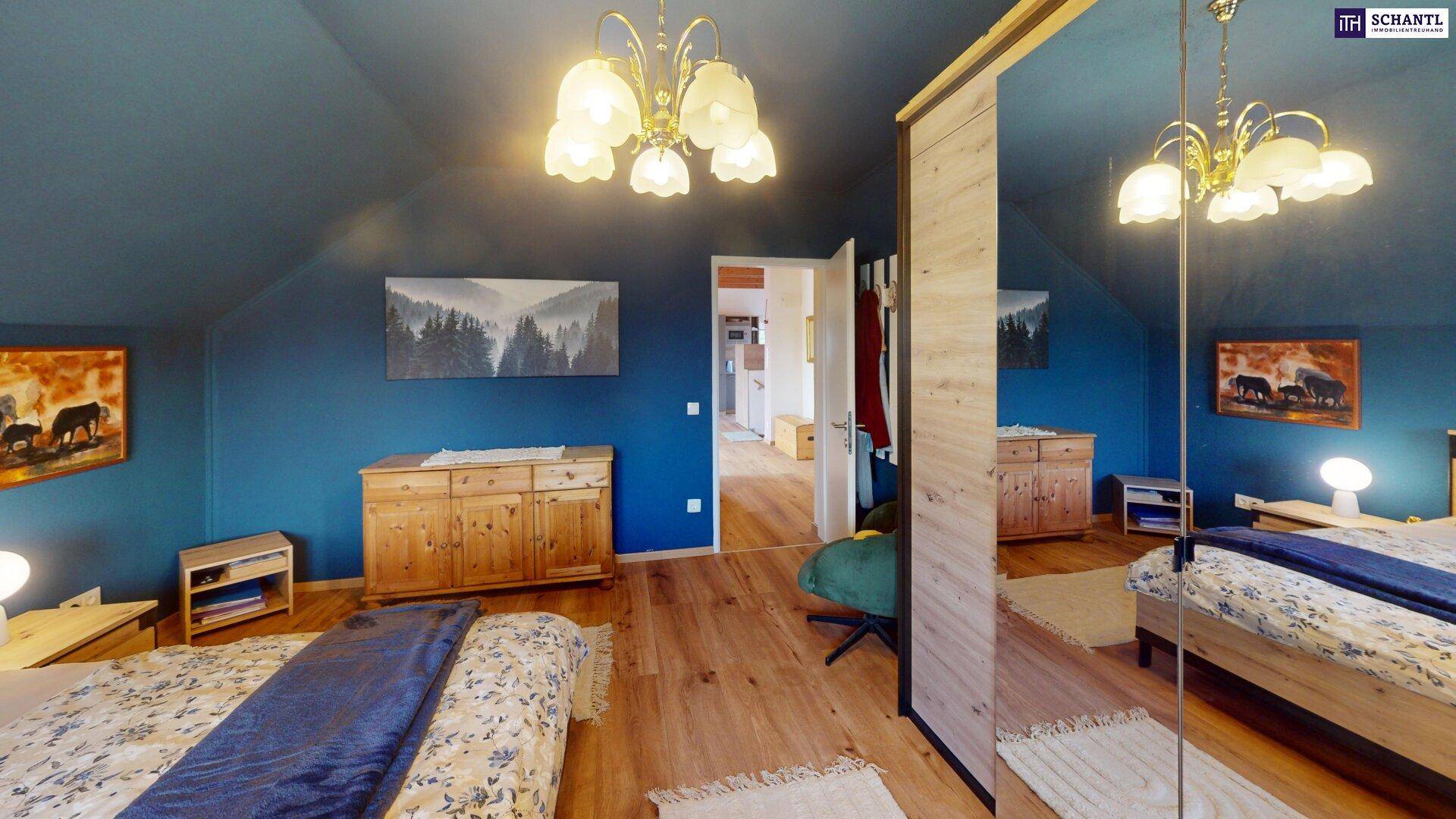 Schlafzimmer mit blauen Wänden, Holzboden und Spiegelschränken, offen zum Flur.