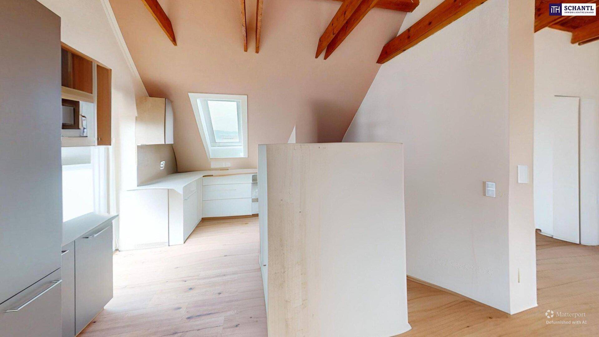 Küche im Dachgeschoss mit Einbauschränken, Dachfenster und Holzbalken.