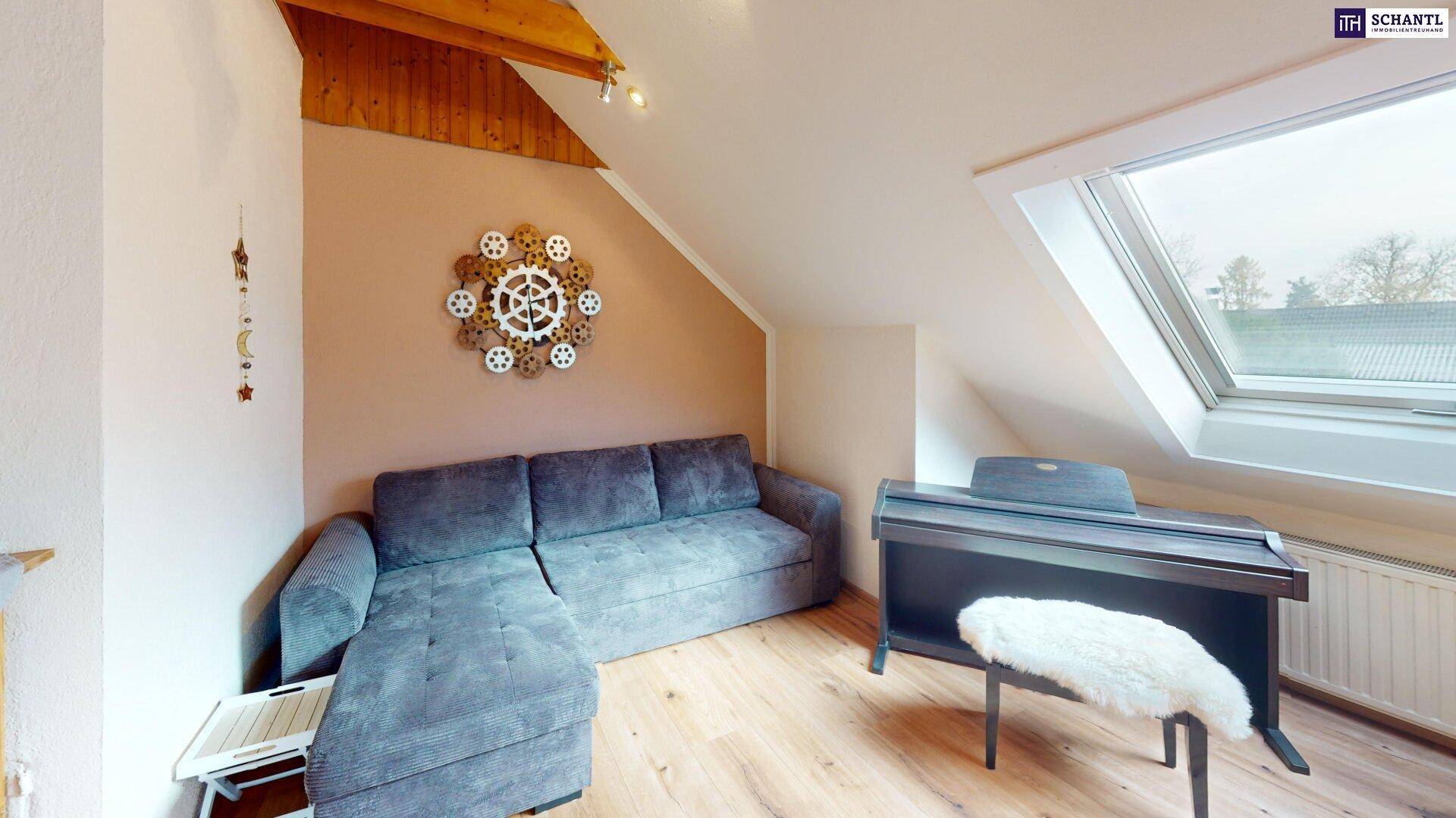 Gemütlicher Wohnbereich im Dachgeschoss mit Sofa, Klavier und Dachfenster.