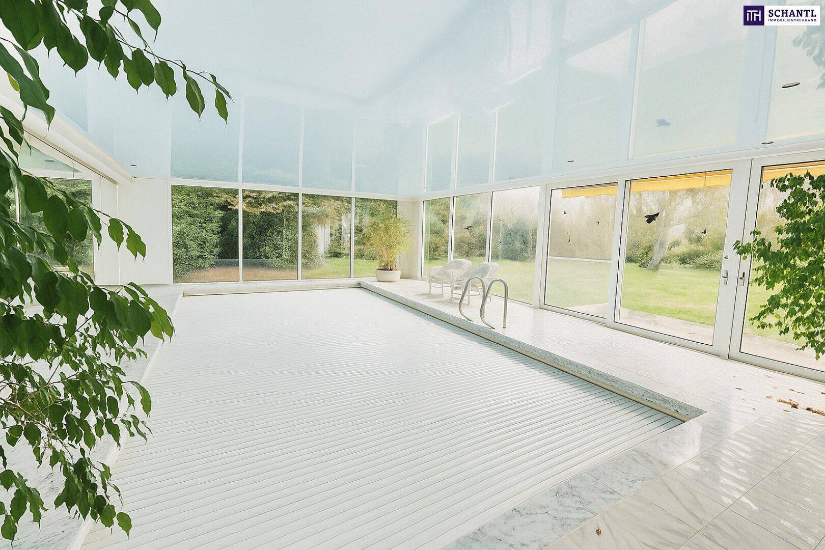 Helle Schwimmhalle mit abgedecktem Pool, großen Fenstern und Blick in den Garten.