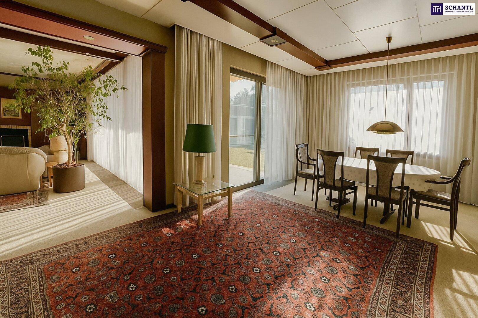 Eleganter Essbereich mit großem Tisch, Stühlen und Zugang zur Terrasse durch große Fenster.