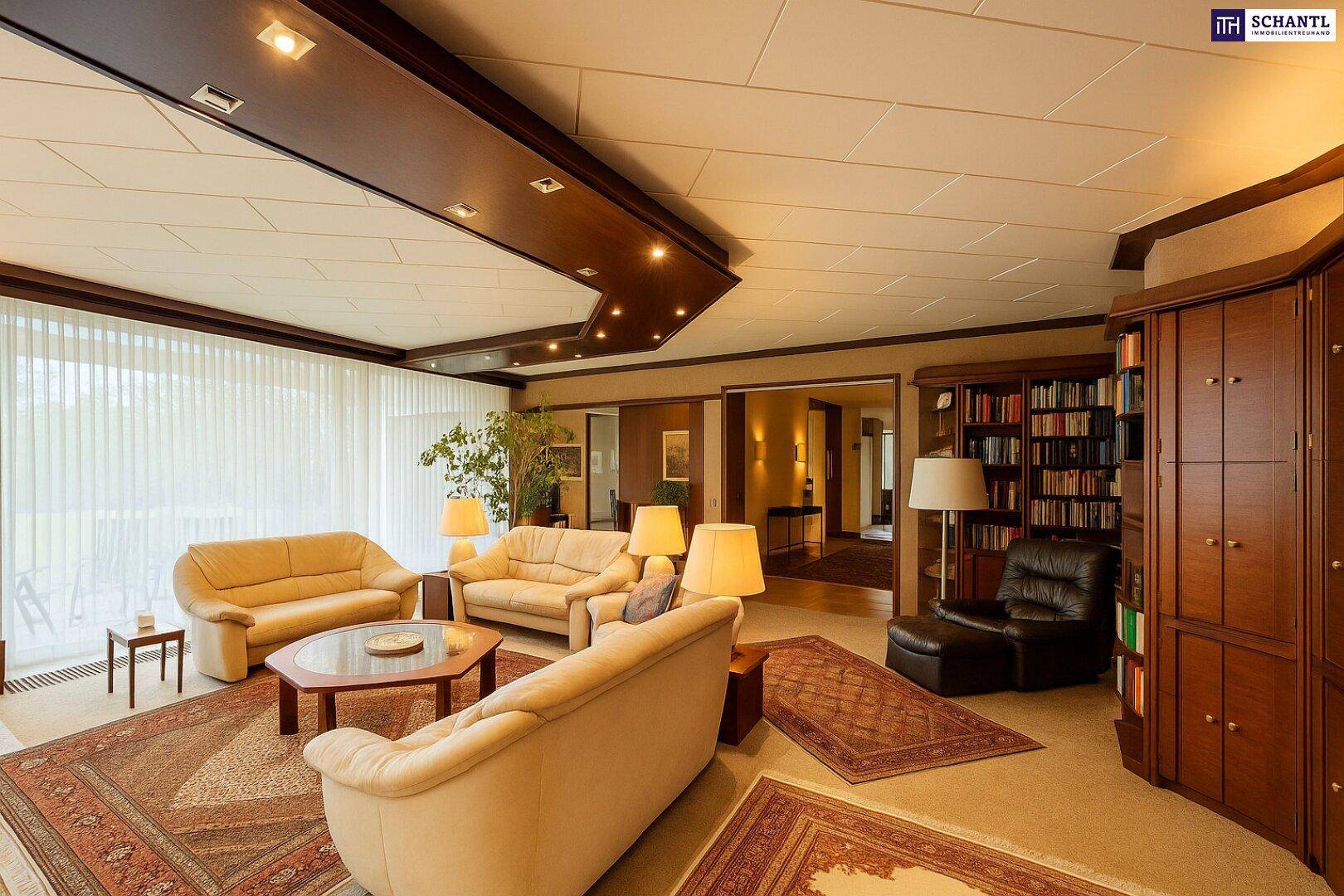 Gemütliches Wohnzimmer mit beigen Sofas, Teppichen und integrierten Bücherregalen.