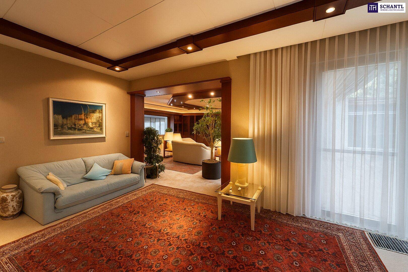 Helles Wohnzimmer mit hellblauem Sofa und offenem Übergang zu weiteren Wohnbereichen.