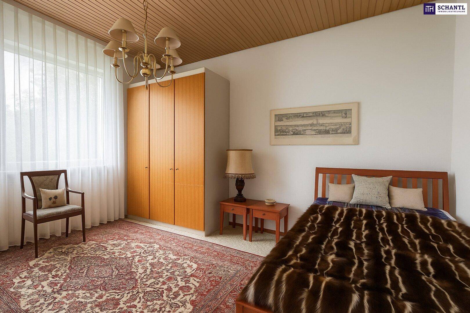 Schlafzimmer mit Holzbett, großem Kleiderschrank und Teppichboden.