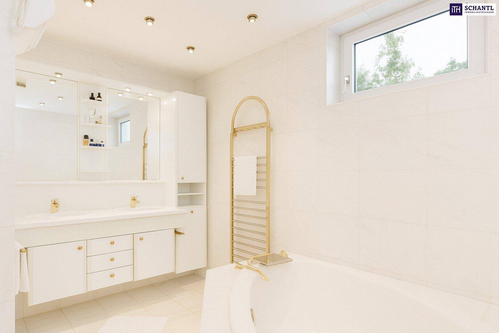 Modernes Badezimmer mit Doppelwaschbecken, Badewanne, goldenen Armaturen und einem Fenster für Tageslicht.