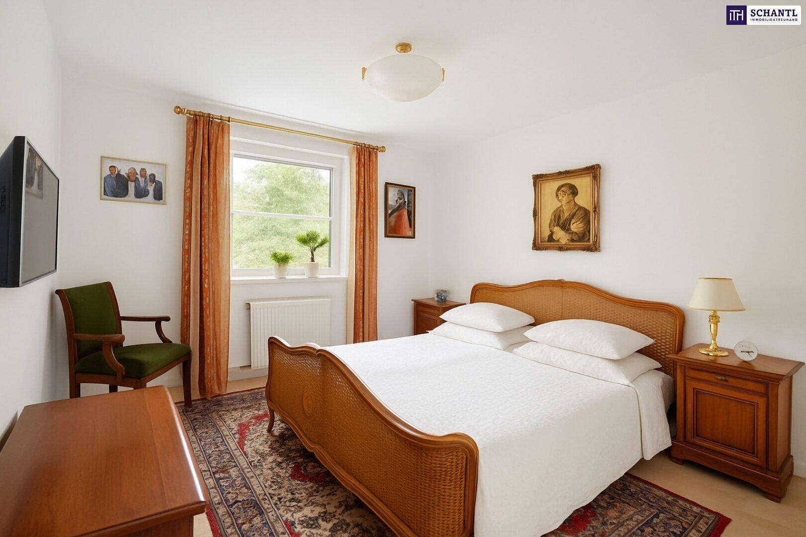 Traditionelles Schlafzimmer mit einem Rattanbett, klassischen Holzmöbeln und einem Fenster mit Blick ins Grüne.