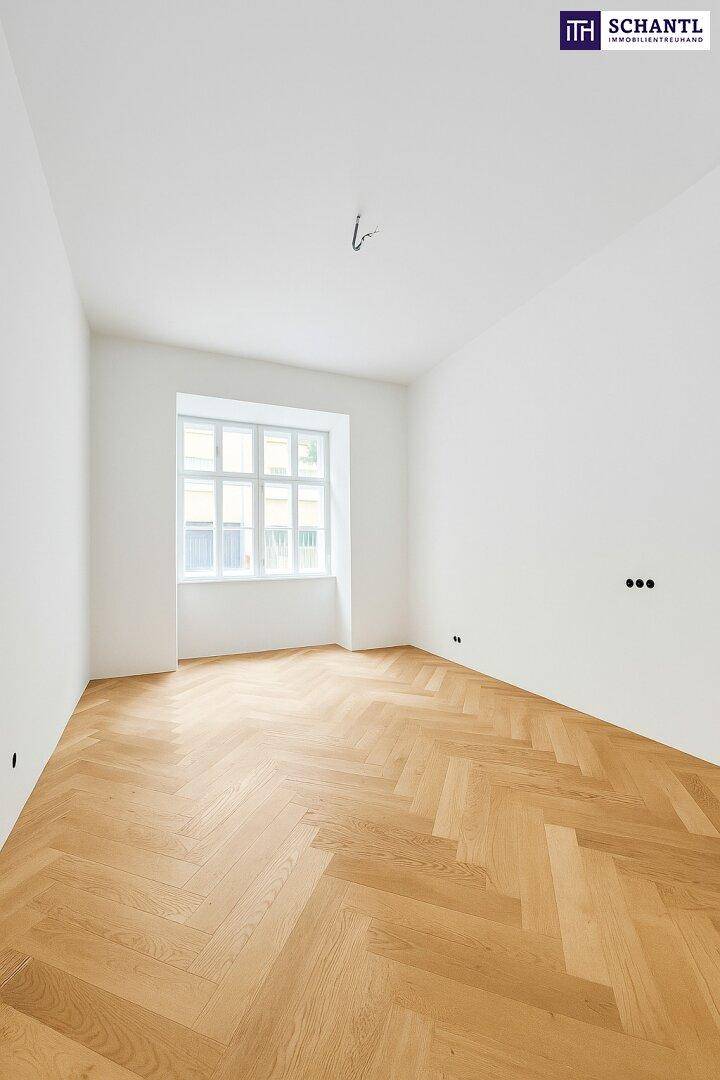 Heller, leerer Raum mit Fischgrätparkett und einem großen Fenster, ideal für individuelle Gestaltung.
