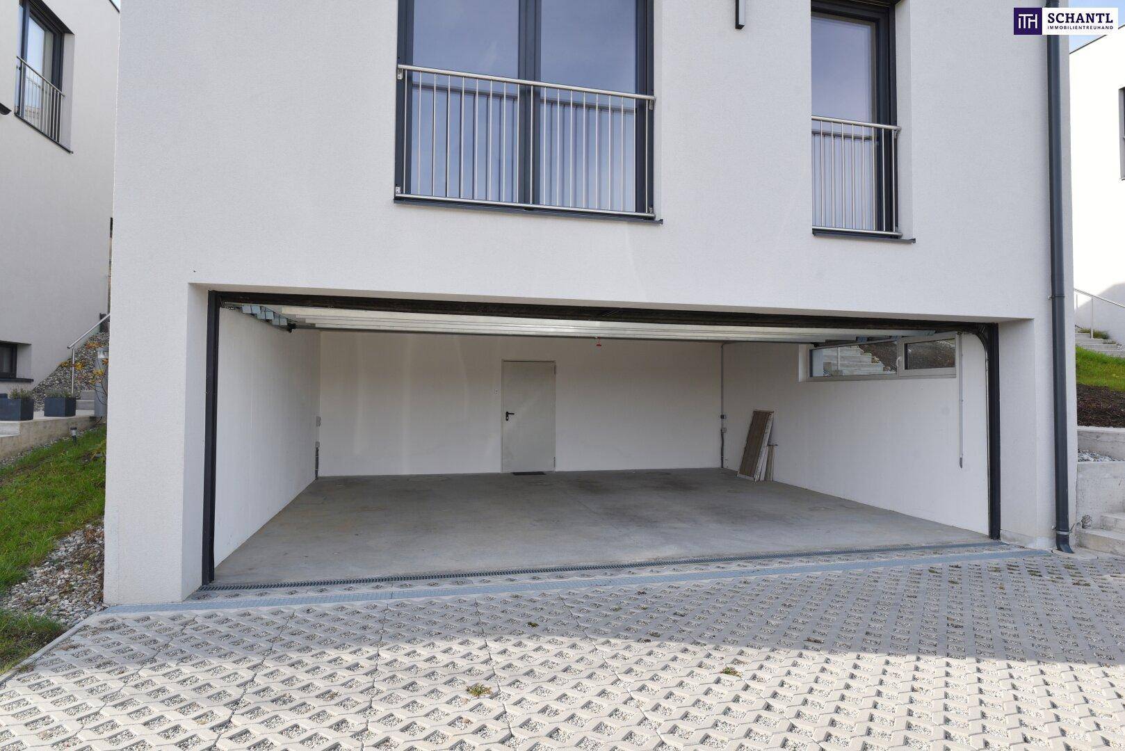 Geräumige Doppelgarage mit Betonboden und direktem Zugang zum Innenbereich des Hauses.