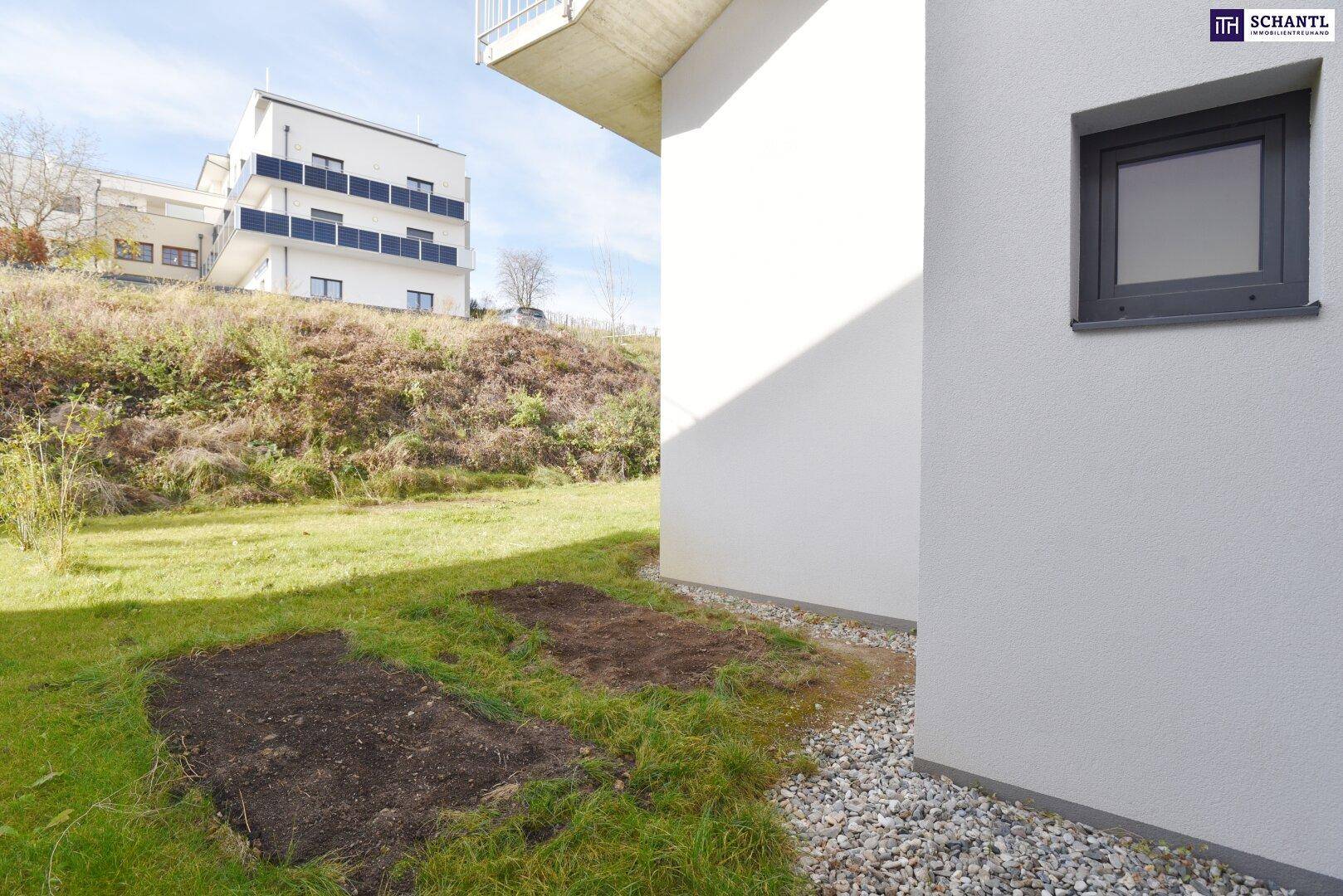 Seitlicher Gartenbereich mit Kiesweg und vorbereiteten Beeten neben dem Gebäude.