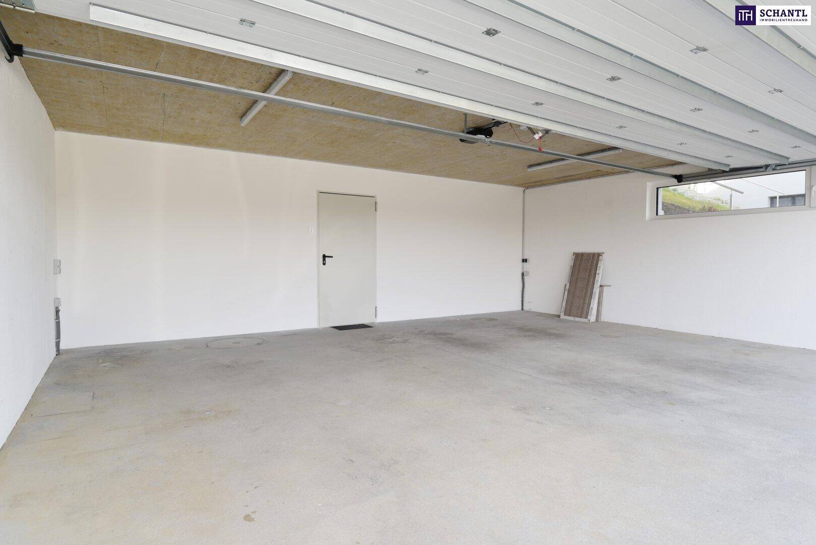 Leere Garage mit Betonboden und weiß gestrichenen Wänden, bereit zur Nutzung.