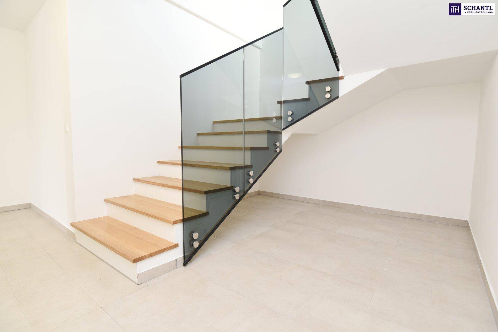 Elegante Holztreppe mit transparentem Glasgeländer, die verschiedene Ebenen verbindet.