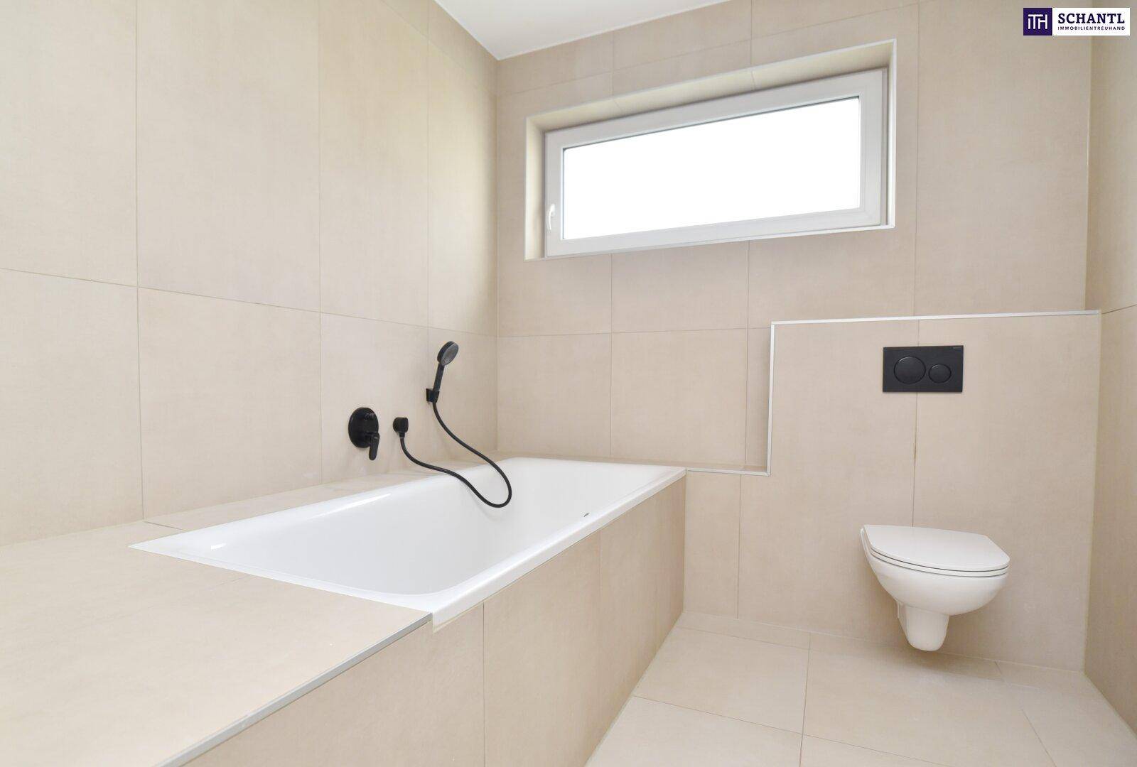 Helles Badezimmer mit beigefarbenen Fliesen, Badewanne, wandhängendem WC und Fenster.