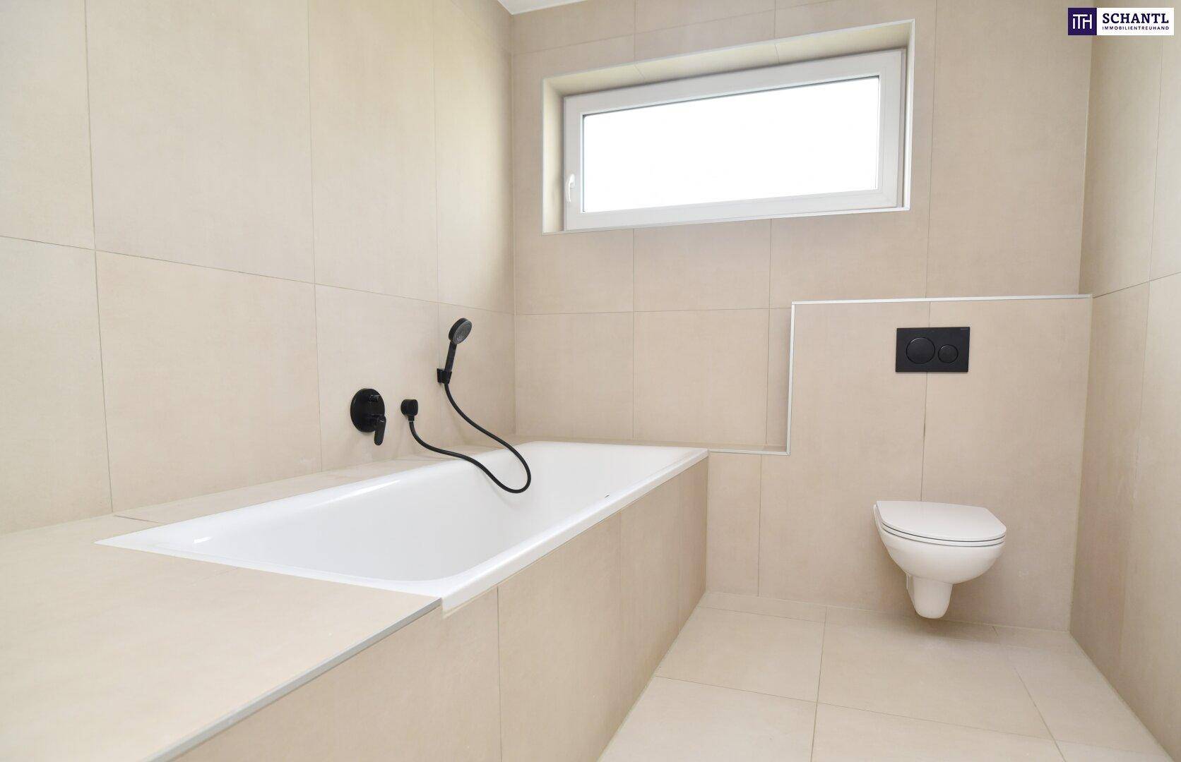 Modernes Badezimmer mit beigefarbenen Fliesen, Badewanne, wandhängendem WC und Fenster.