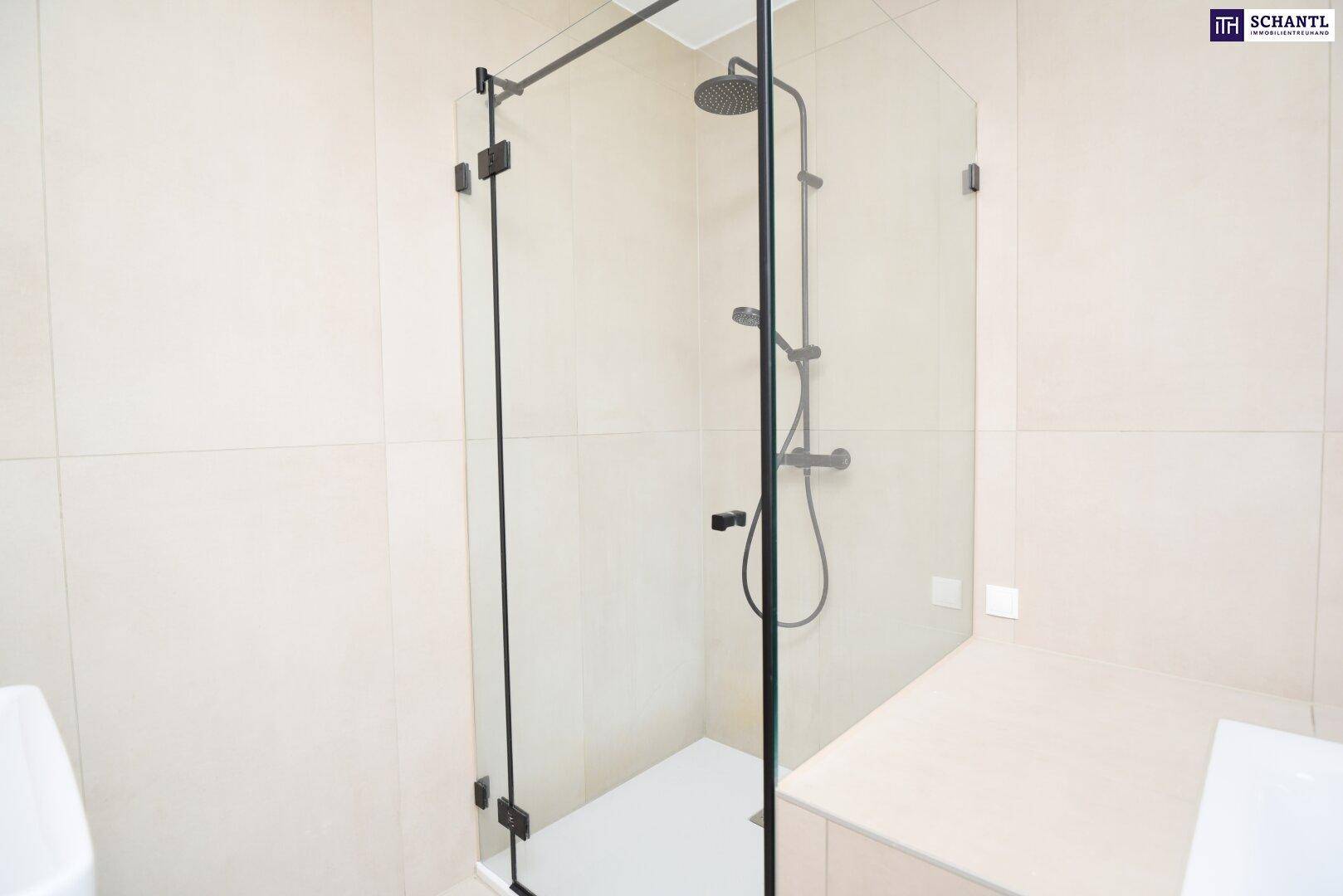 Moderne begehbare Dusche mit Glasabtrennung und schwarzer Armatur in einem hellen Bad.
