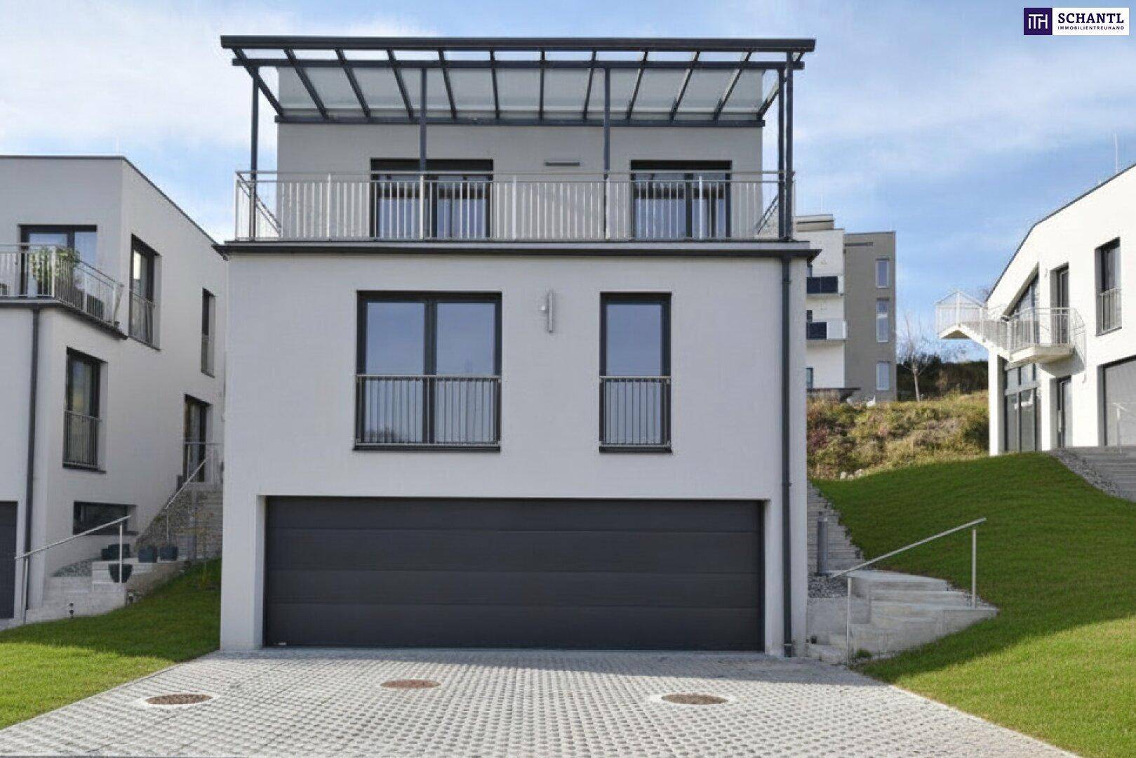 Moderne Hausfassade mit integrierter Doppelgarage und überdachtem Balkon im Obergeschoss.