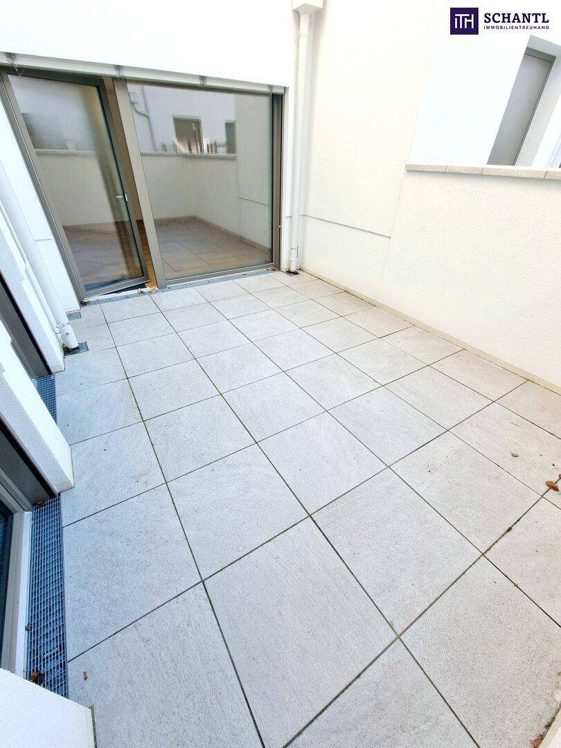 Sonniger, gefliester Terrassenbereich mit Zugang zu den Innenräumen.