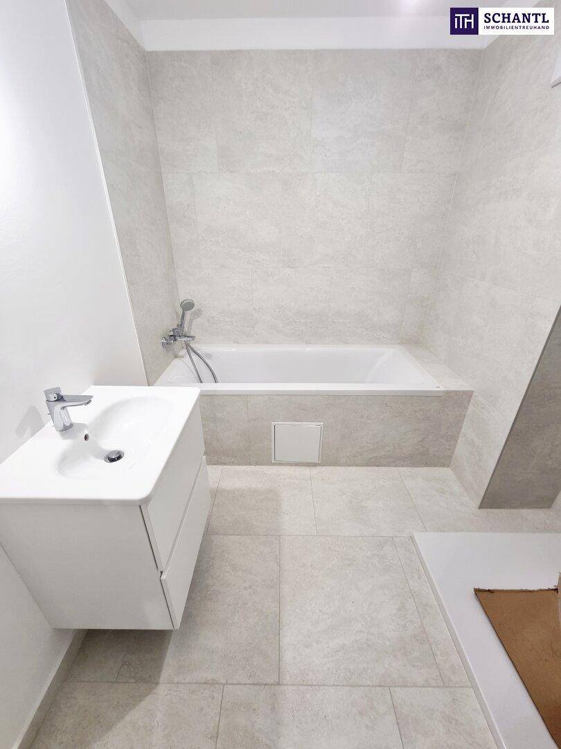 Modernes Badezimmer mit Badewanne, Waschbecken und hellen Fliesen.