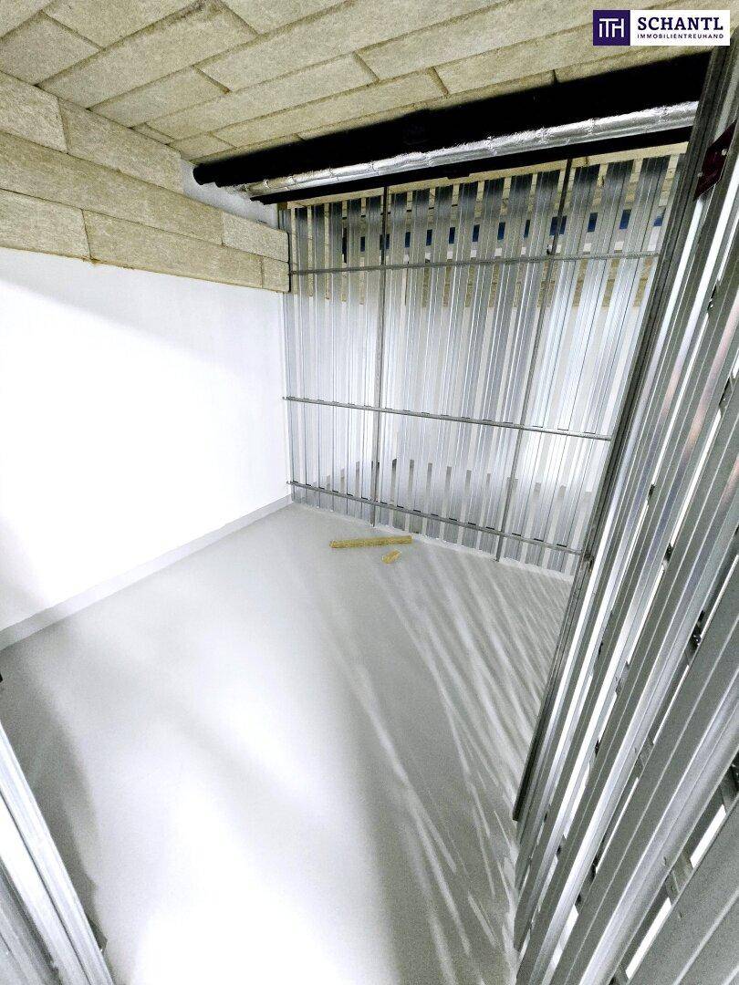 Kellerabteil mit Metallabtrennungen und hellem Boden.