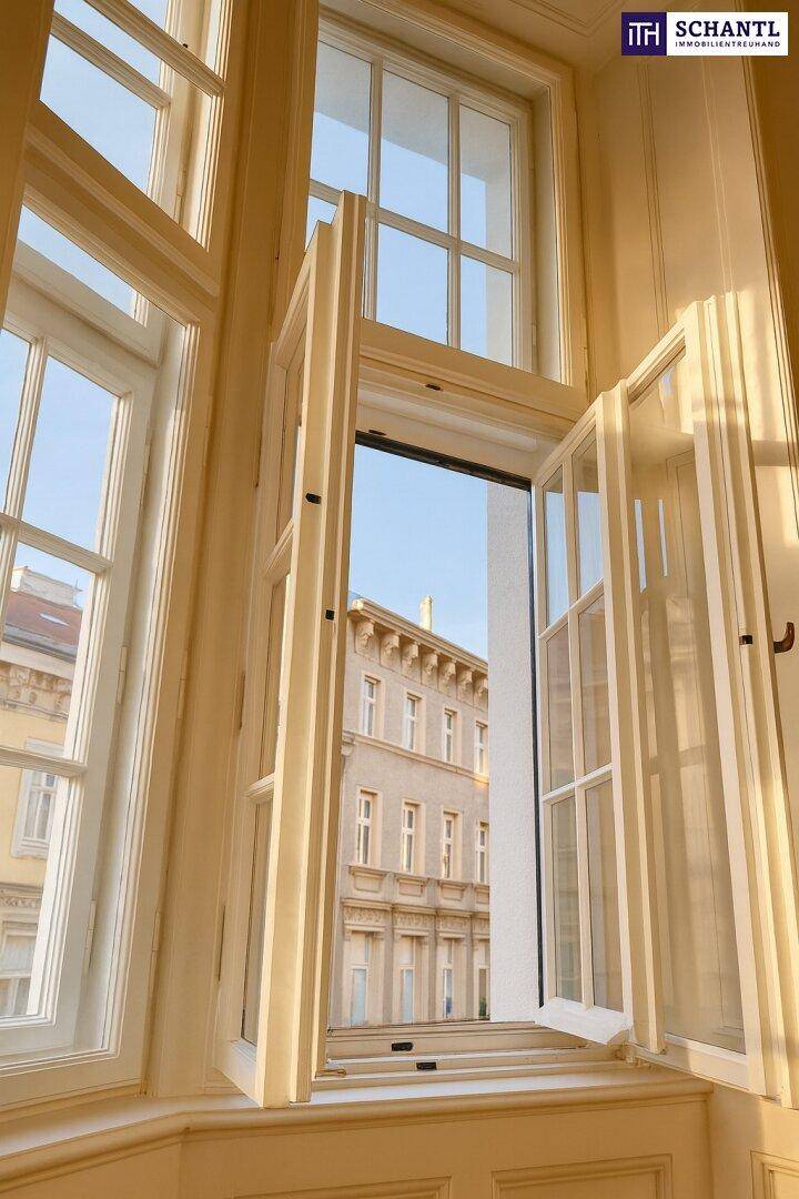 Detailansicht eines großen Fensters mit Blick auf die gegenüberliegende historische Fassade.
