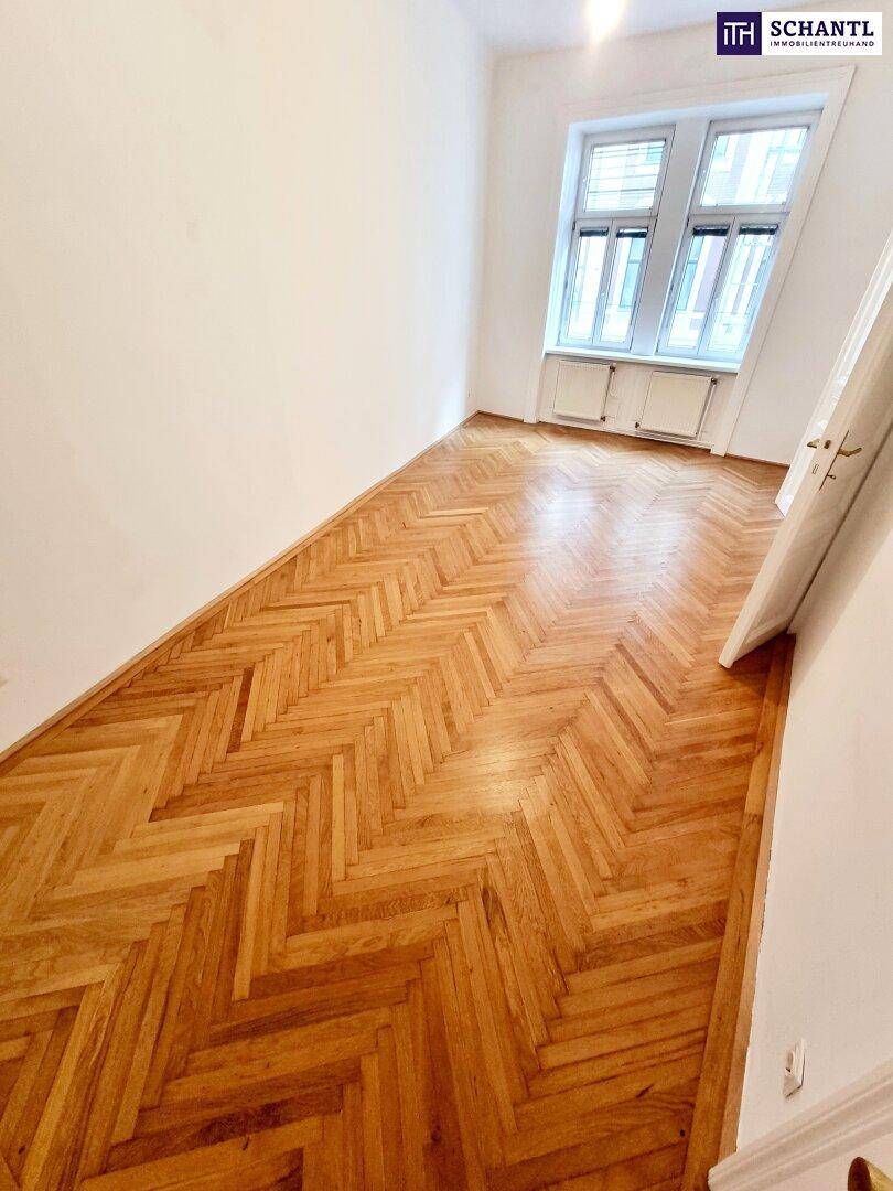 Heller Raum mit Fischgrätparkett und einem großen Fenster, das viel Tageslicht in den Raum bringt.