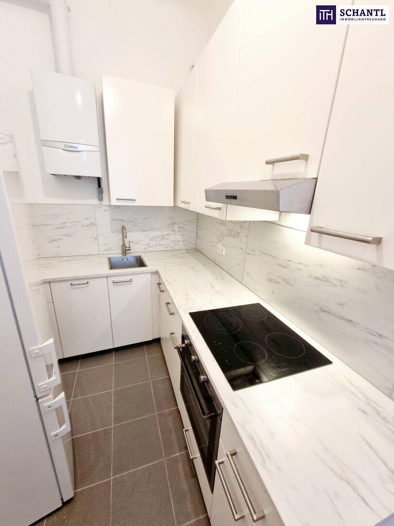 Kompakte, moderne Küche mit weißen Schränken, Induktionskochfeld und integriertem Backofen.