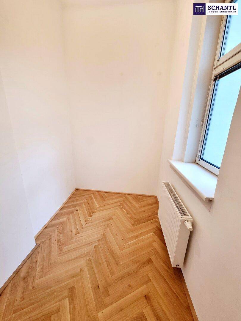 Kleiner, heller Raum mit Fischgrätparkett und einem Fenster, ideal als Schlaf- oder Arbeitszimmer.
