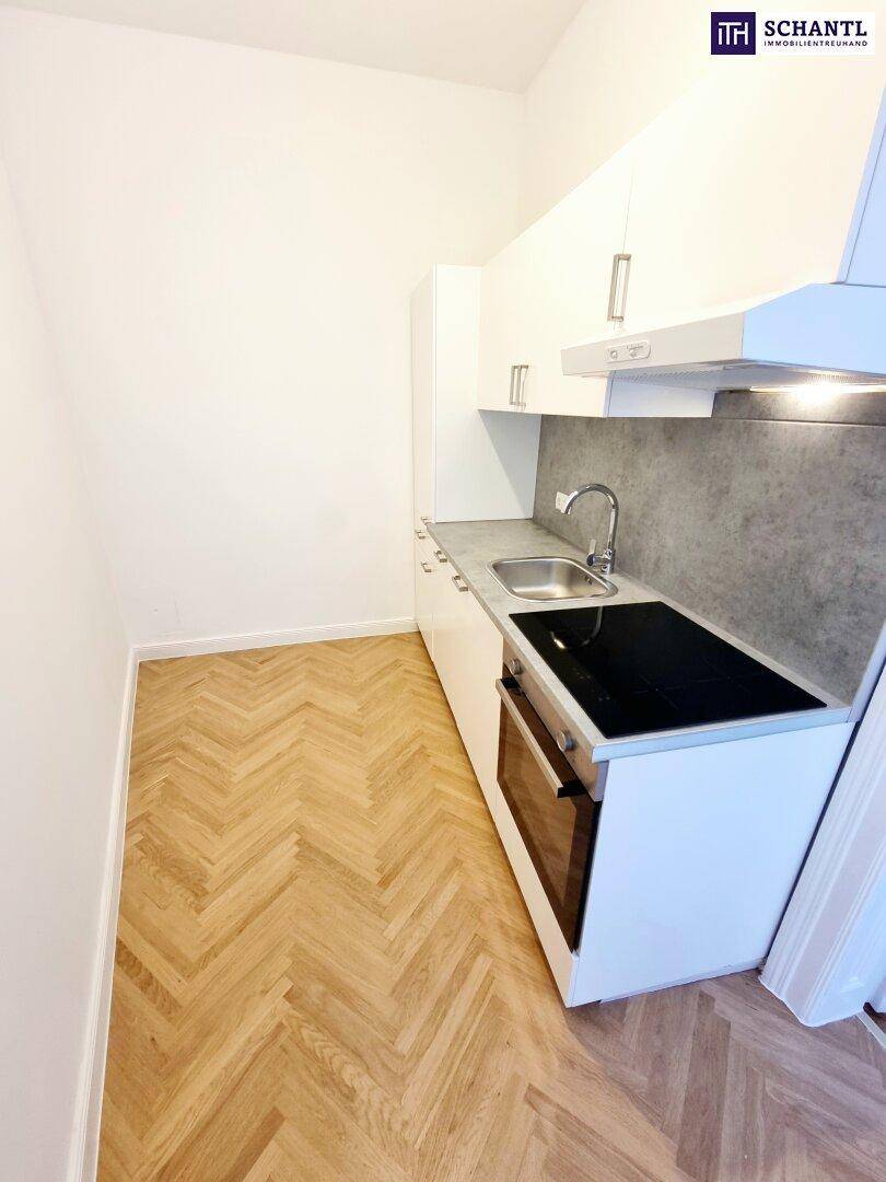 Kompakte Küchenzeile mit weißen Schränken, Induktionskochfeld und integriertem Backofen, praktisch und modern.