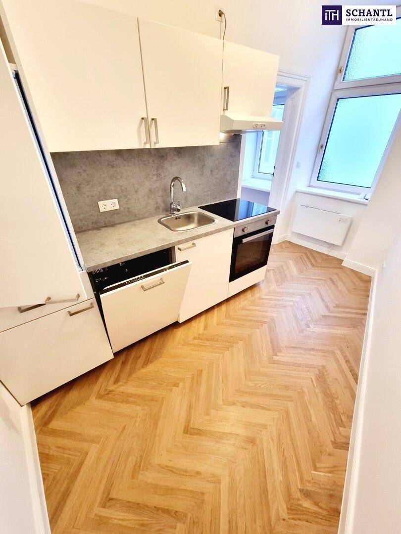 Moderne Küchenzeile mit weißen Schränken, Induktionskochfeld und integriertem Backofen.