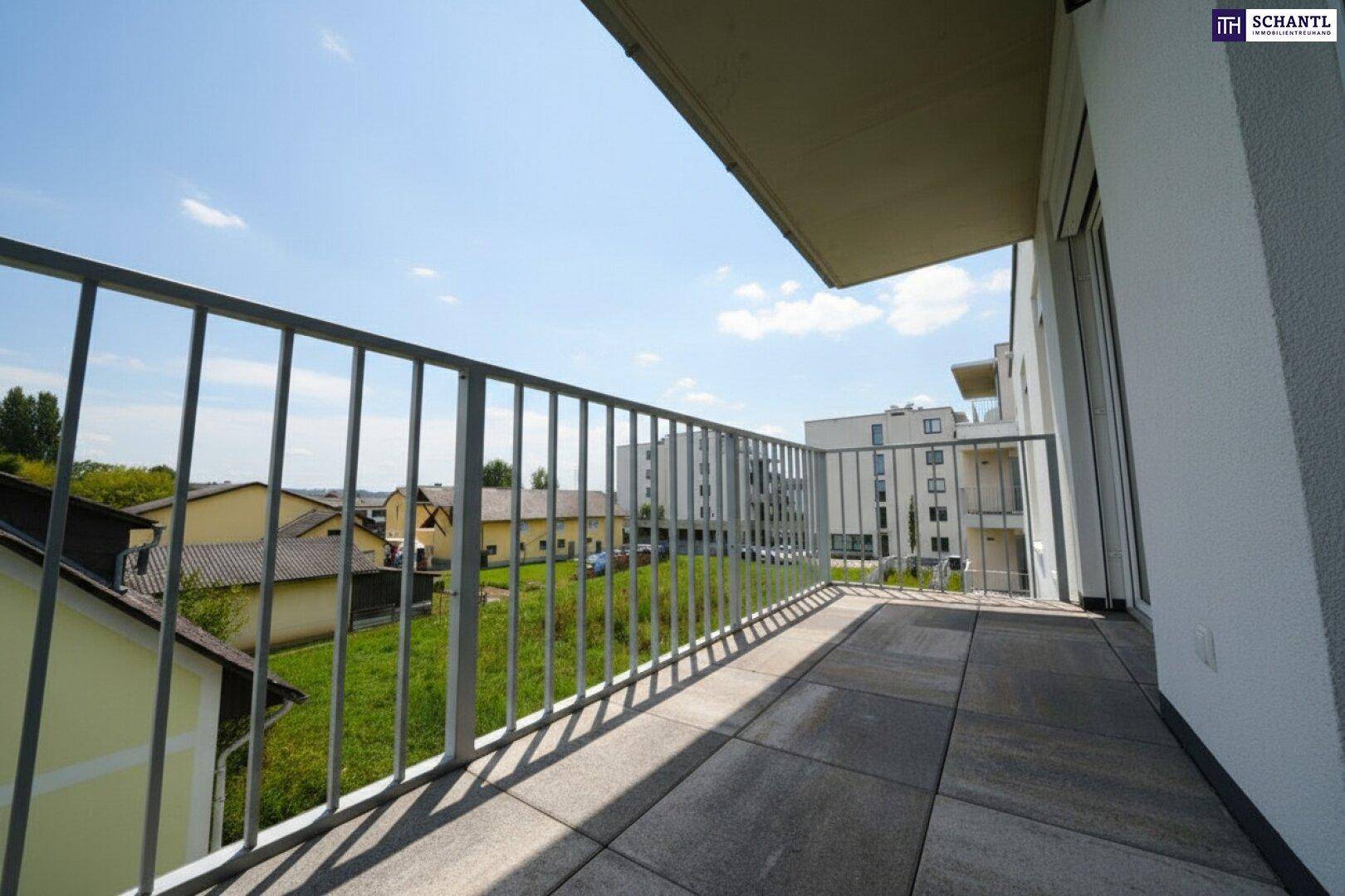 Geräumiger Balkon mit Fliesenboden und Blick auf die umliegende Wohngegend und Grünflächen.