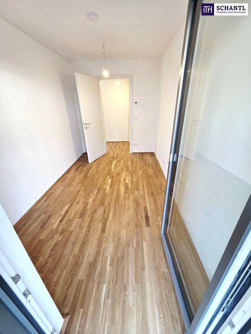 Helles Zimmer mit Parkettboden und Zugang zum Außenbereich, ideal als Schlaf- oder Arbeitszimmer.