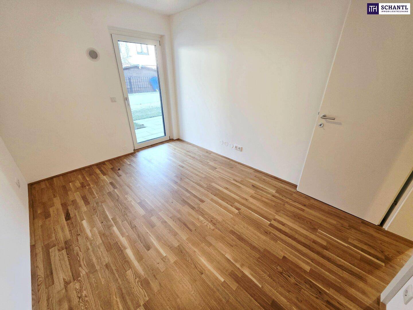 Helles Zimmer mit Parkettboden und direktem Zugang zum Gartenbereich.