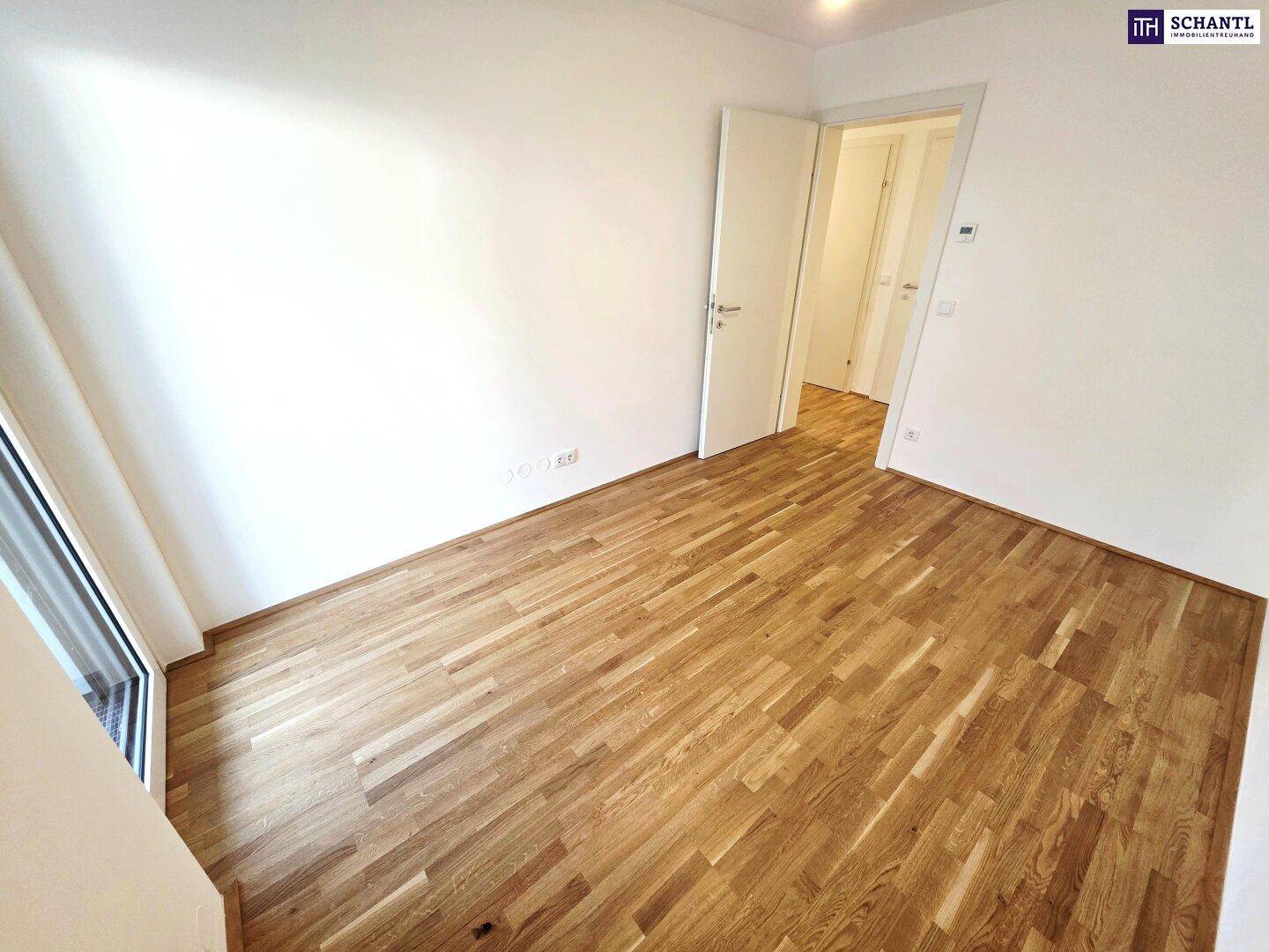 Helles Zimmer mit Parkettboden und weißen Wänden, ideal als Schlaf- oder Kinderzimmer.