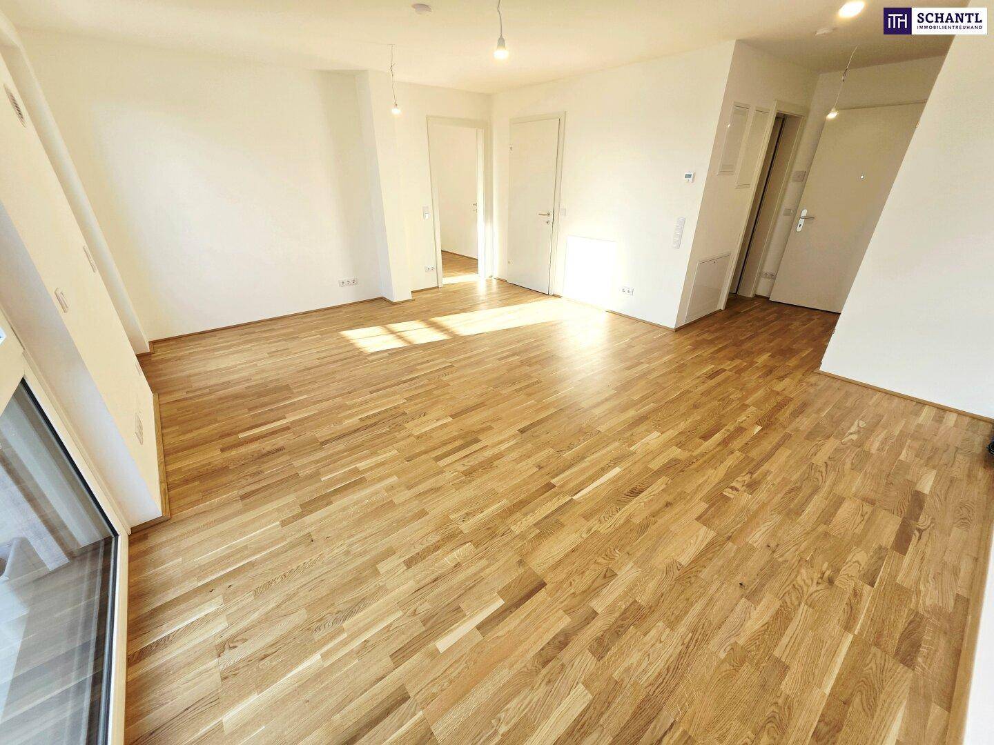 Geräumiges, helles Zimmer mit Holzboden und schrägen Wänden, das viel Potenzial bietet.