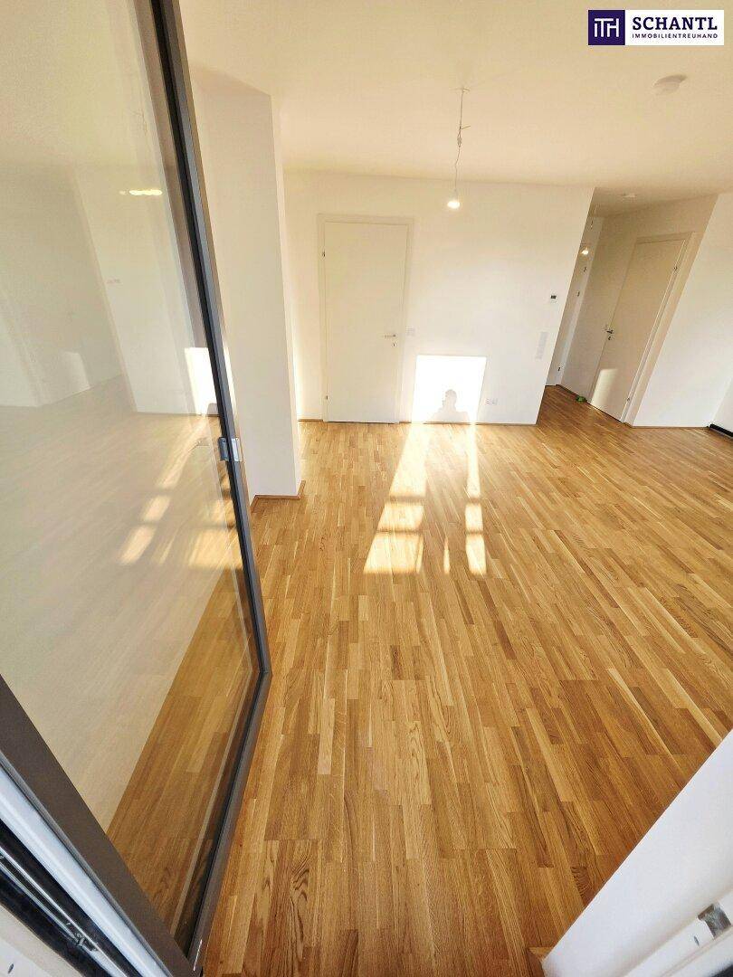 Lichtdurchfluteter Raum mit Holzboden und Zugang zu einem Außenbereich, ideal für modernes Wohnen.
