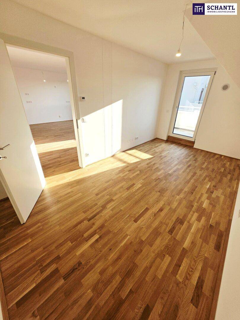 Helles Zimmer mit Holzboden und Zugang zu einem Balkon, ideal als Schlaf- oder Arbeitszimmer.