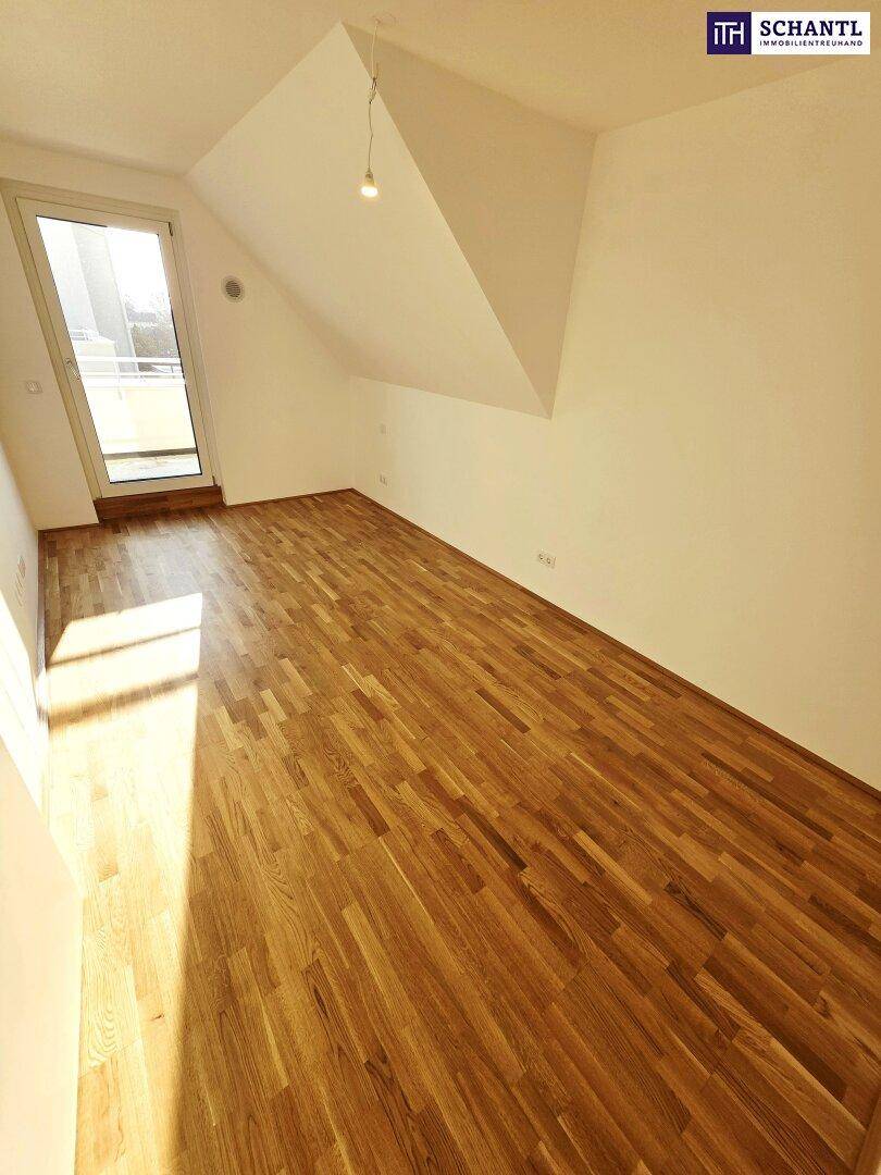 Helles Zimmer mit Holzboden und schräger Decke, ideal als Schlaf- oder Arbeitszimmer.